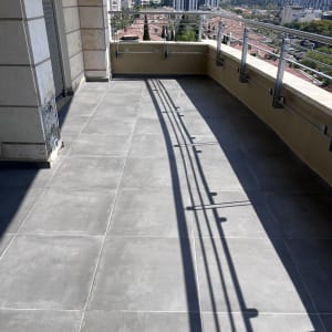 מרפסת עם רצפה נקייה ומעקה מתכת