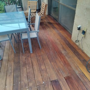 רצפת דק עץ עם שולחן וכיסאות גינה