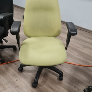 כיסא משרדי ירוק על רצפת עץ
