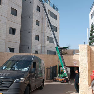 מנוף ירוק מרים חפצים לגג בניין