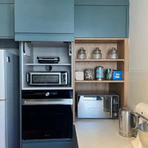 מדפים עם צנצנות, טוסטר, מיקרוגל וקומקום חשמלי