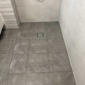 ריצוף חדש בחדר אמבטיה עם ניקוז רצפה.