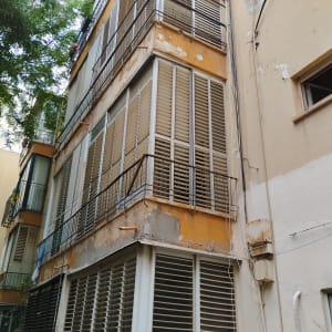 תריסים לבנים על בניין מגורים ישן