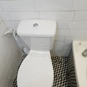 אסלה לבנה עם צינור חיבור לקיר