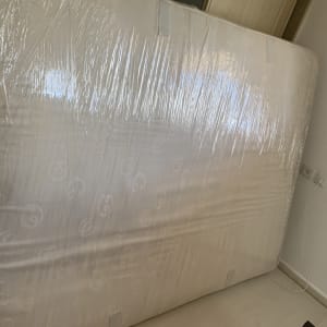 מזרן עטוף בניילון עומד בחדר ריק