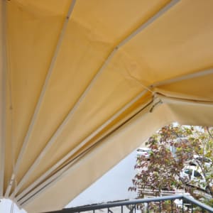 סוכך בד צהוב עם מסגרת מתכת לבנה