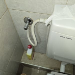 אסלה עם צינור מים ובקבוק חומר ניקוי
