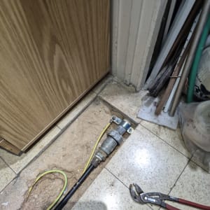 צינור מים פתוח עם כלי עבודה על הרצפה