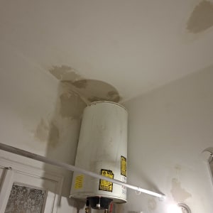 דוד מים עם סימני רטיבות על הקיר והתקרה