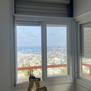 תריסים פתוחים עם נוף לים וסולם בחדר