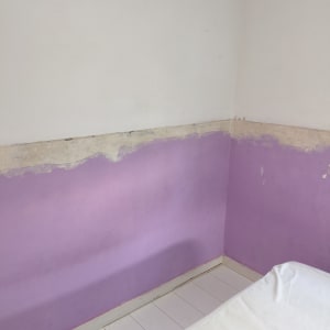 קיר צבוע חלקית בצבע סגול ולבן