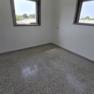 חדר ריק עם קירות לבנים ורצפת אריחים