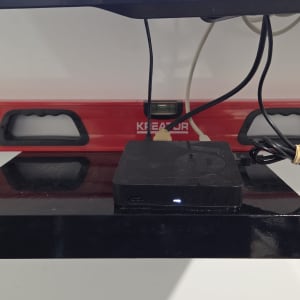 מדף עם מכשיר אלקטרוני ומפלס בנייה אדום