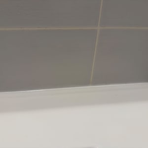 איטום בסיליקון לבן בחיבור בין אריחי הקיר לאמבטיה או כיור