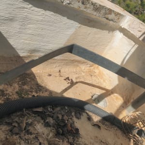 צינור וגדר מתכת ליד קיר אטום