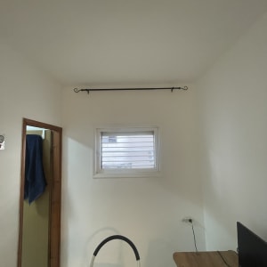 סולם קטן ליד חלון עם וילון מותקן