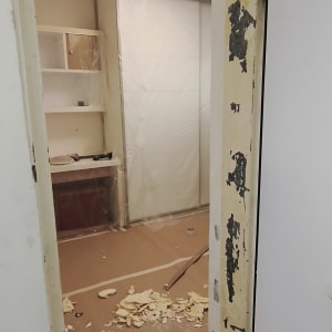 חדר בשיפוץ עם קירות מתקלפים וציוד כיסוי