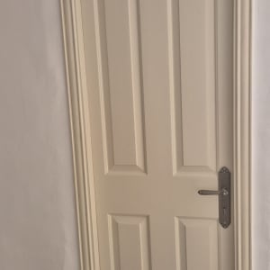 דלת עץ צבועה בצבע בהיר עם ידית מתכת