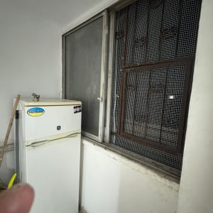 מקרר ליד חלון עם סורגים