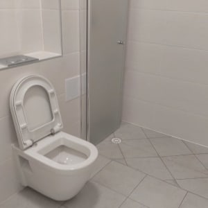 שירותים נקיים עם רצפה מרוצפת ודלת זכוכית