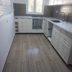 מטבח בשיפוץ עם ארונות פתוחים ומשטח עבודה חדש