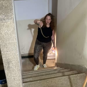 אישה מחזיקה נחש במדרגות עם פנס