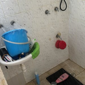 דלי כחול על כיור בחדר אמבטיה עם ברזים