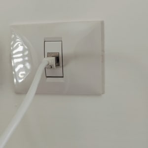 שקע רשת עם כבל מחובר לקיר לבן