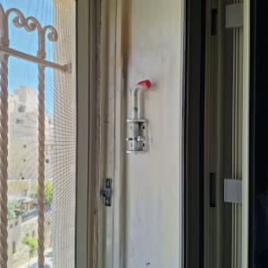 חלון עם סורג מתכת ומנגנון נעילה