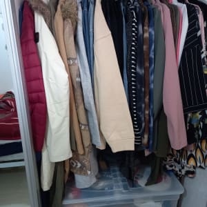 בגדים תלויים בארון עם קופסאות פלסטיק לאחסון