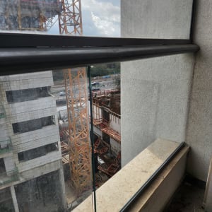 מעקה זכוכית במרפסת עם נוף לאתר בנייה