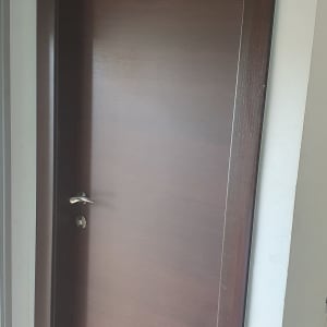 דלת עץ חומה עם ידית מתכת כסופה