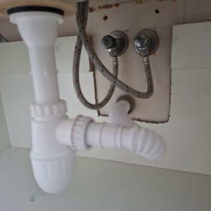 צנרת מתחת לכיור עם חיבורים וצינורות