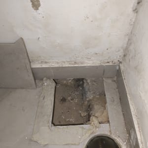 תמונה של קיר ורצפה עם חור ותעלת ניקוז