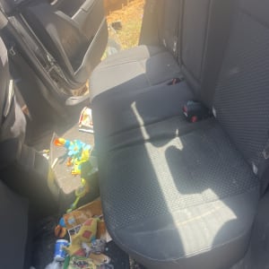 מושב רכב עם צעצועים ופסולת על הרצפה