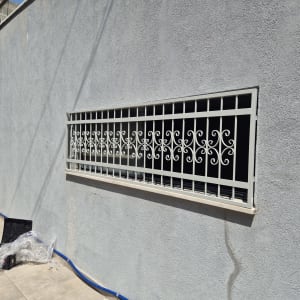 סורג מתכת על קיר חיצוני עם כלים על הרצפה