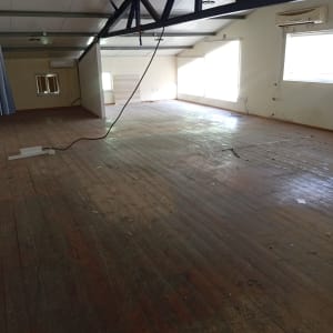 חדר ריק עם רצפת עץ ותקרה גבוהה