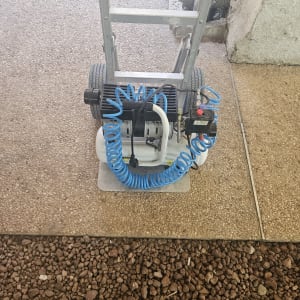 מכשיר עם צינור כחול על רצפה מרוצפת