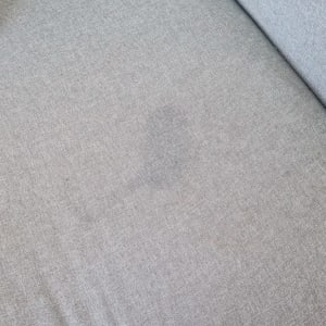 כתם כהה על ספת בד אפורה