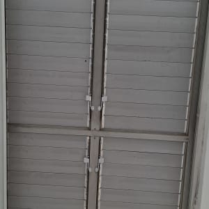 תריסים סגורים על חלון עם מסגרת מתכת