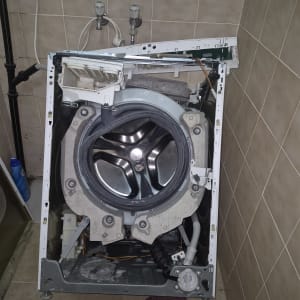 מכונת כביסה פתוחה לתיקון בחדר אמבטיה