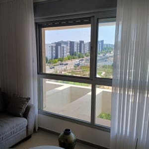 חלון אלומיניום עם נוף לבניינים וכביש