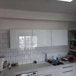 מטבח עם ארונות לבנים, כיור וכלים על השיש