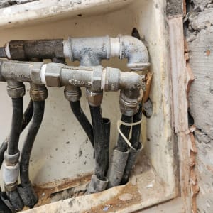 צינורות מתכת וחיבורים בקיר במהלך שיפוץ