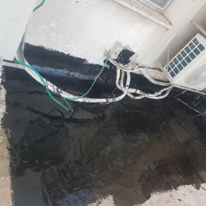 איטום גג בזפת שחורה ליד מזגנים וצינורות