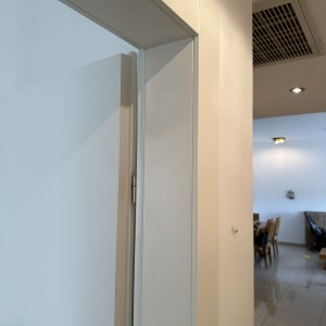 דלת לבנה פתוחה עם ציר מתכת על הקיר