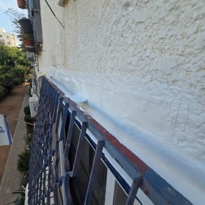 איטום קיר חיצוני עם חומר לבן ליד חלון