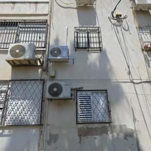 בניין עם מזגנים מותקנים על הקיר החיצוני