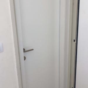 דלת לבנה עם ידית מתכת כסופה