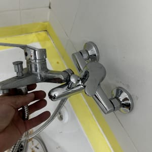 ברז אמבטיה מותקן על קיר עם יד אוחזת